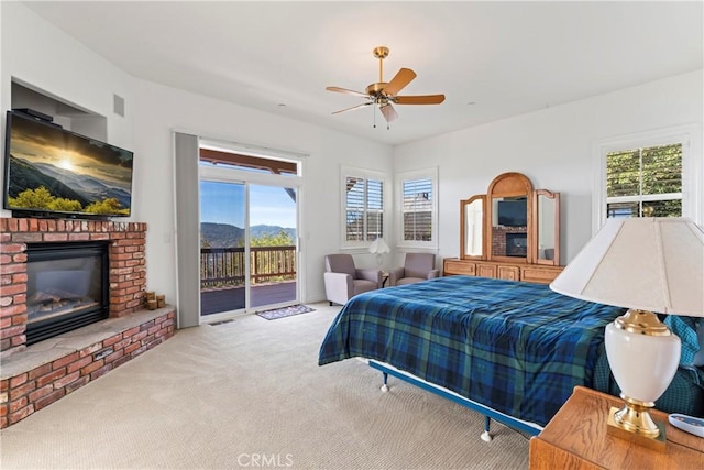 29083 Mammoth Dr, Lake Arrowhead, CA 92352 - carpeted bedroom featuring access to exterior, multiple windows, a fireplace, and a ceiling fan