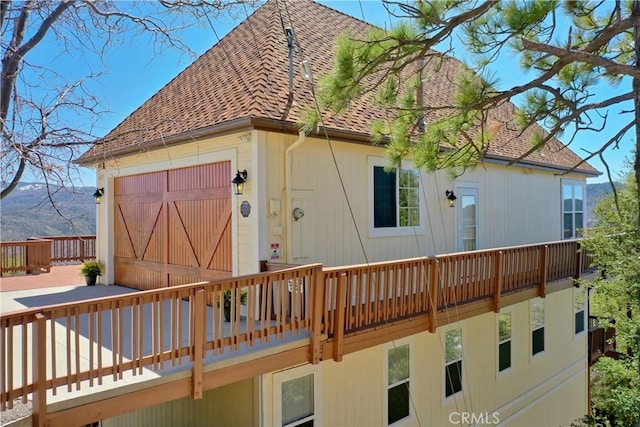 29083 Mammoth Dr, Lake Arrowhead, CA 92352 - rear view of property with roof with shingles, a deck with mountain view, and an attached garage