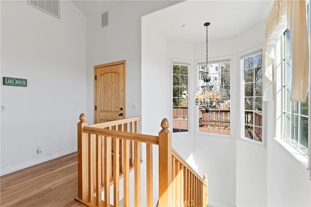 29083 Mammoth Dr, Lake Arrowhead, CA 92352 - hallway with an upstairs landing, a chandelier, wood finished floors, healthy amount of natural light, and a high ceiling