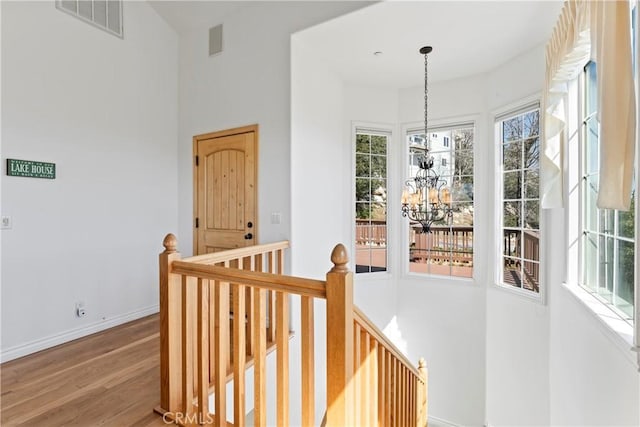 29083 Mammoth Dr, Lake Arrowhead, CA 92352 - hall featuring an upstairs landing, a chandelier, healthy amount of natural light, wood finished floors, and a towering ceiling