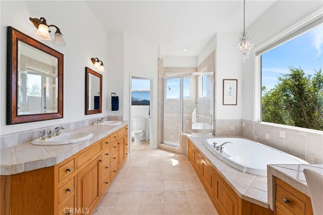 29083 Mammoth Dr, Lake Arrowhead, CA 92352 - bathroom with a bath, a shower stall, double vanity, and a chandelier