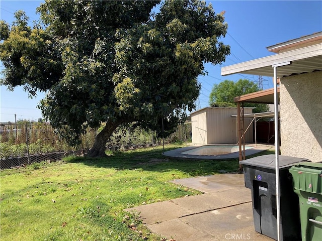 view of yard featuring a storage shed, fence, a patio, an outbuilding, and a swimming pool