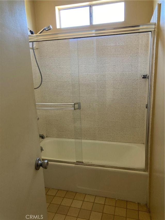 bathroom featuring tile patterned floors and shower / bath combination with glass door