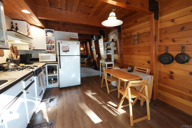 206 Cedar Ln, Sugarloaf, CA 92386 - kitchen with white appliances, dark wood-type flooring, open shelves, white cabinetry, and wood walls