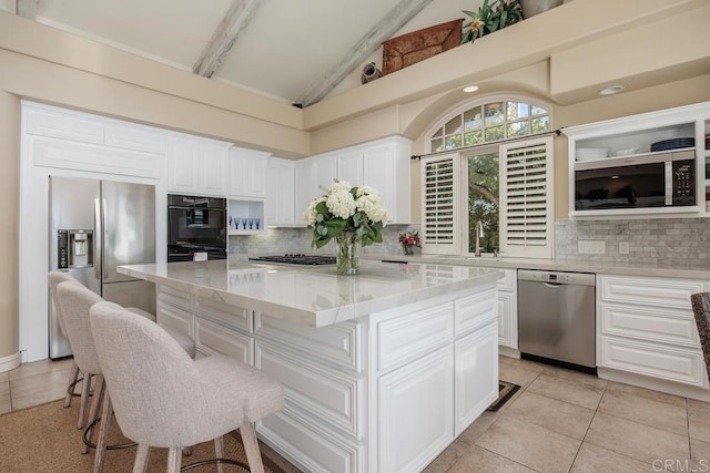 7189 Aviara Dr, Carlsbad, CA 92011 - kitchen featuring stainless steel appliances, light stone counters, backsplash, white cabinets, and high vaulted ceiling