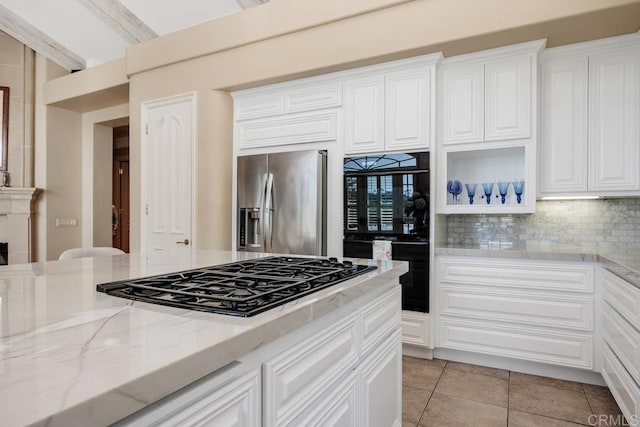 7189 Aviara Dr, Carlsbad, CA 92011 - kitchen featuring black appliances, light stone counters, decorative backsplash, white cabinetry, and light tile patterned flooring