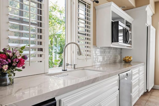 7189 Aviara Dr, Carlsbad, CA 92011 - kitchen with appliances with stainless steel finishes, decorative backsplash, a sink, white cabinetry, and light stone countertops