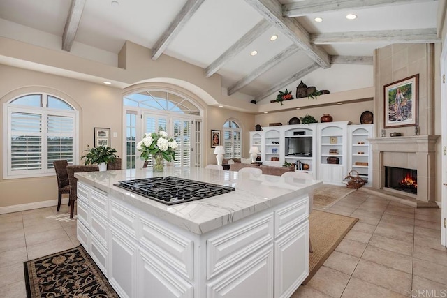 7189 Aviara Dr, Carlsbad, CA 92011 - kitchen with stainless steel gas stovetop, open floor plan, light tile patterned floors, recessed lighting, and a tile fireplace