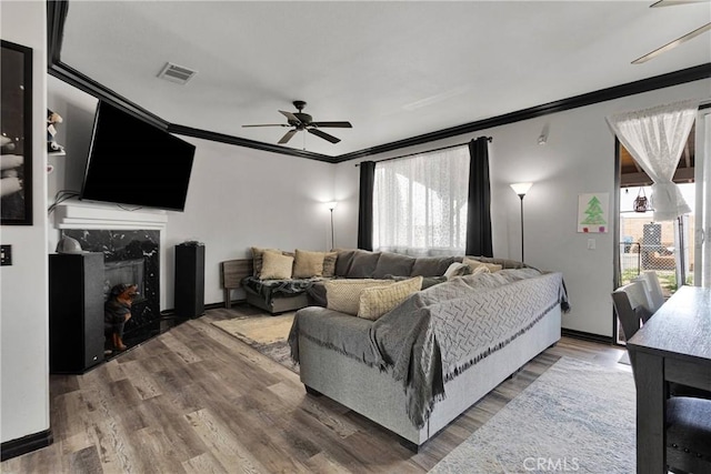 9153 Ravenswood Ave, Hesperia, CA 92344 - living area with a fireplace, crown molding, visible vents, ceiling fan, and wood finished floors