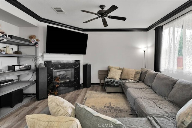 9153 Ravenswood Ave, Hesperia, CA 92344 - living area with ornamental molding, a ceiling fan, visible vents, wood finished floors, and a premium fireplace