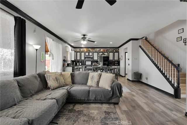9153 Ravenswood Ave, Hesperia, CA 92344 - living area featuring light wood-style flooring, ceiling fan, ornamental molding, and stairway
