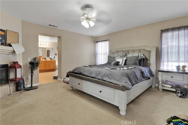 9153 Ravenswood Ave, Hesperia, CA 92344 - bedroom with ceiling fan, ensuite bath, visible vents, light carpet, and baseboards