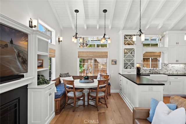 361 Cress St, Laguna Beach, CA 92651 - kitchen featuring light wood-style flooring, beam ceiling, a chandelier, dark countertops, and white cabinetry
