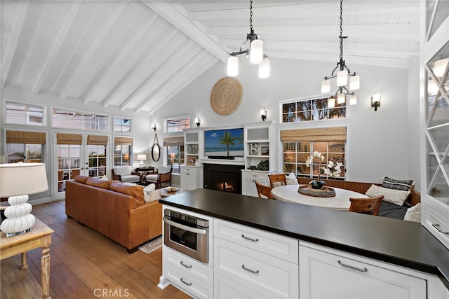 361 Cress St, Laguna Beach, CA 92651 - kitchen featuring a warm lit fireplace, high vaulted ceiling, dark countertops, hardwood / wood-style flooring, and a chandelier