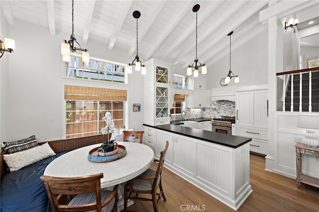 361 Cress St, Laguna Beach, CA 92651 - kitchen with high end range, dark countertops, high vaulted ceiling, dark wood finished floors, and a chandelier