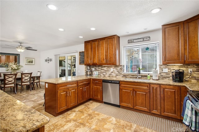 kitchen with a peninsula, tasteful backsplash, light stone counters, brown cabinetry, and appliances with stainless steel finishes