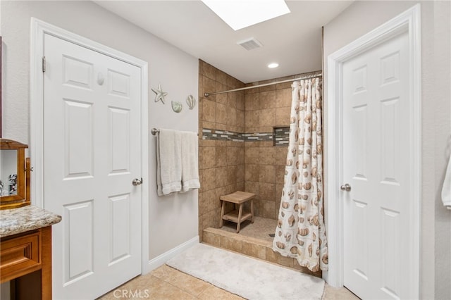 bathroom with baseboards, tile patterned flooring, visible vents, and tiled shower
