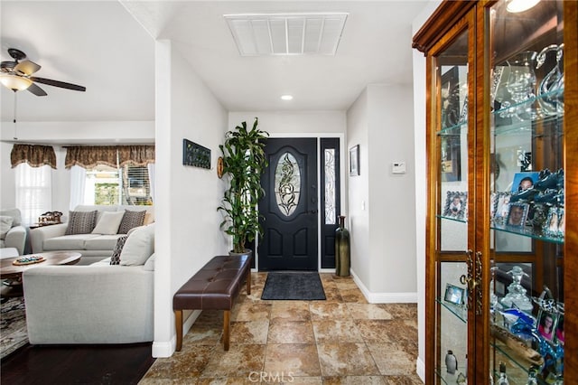 entryway with baseboards, a ceiling fan, visible vents, and stone finish flooring