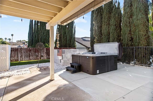 view of patio / terrace with fence and a hot tub