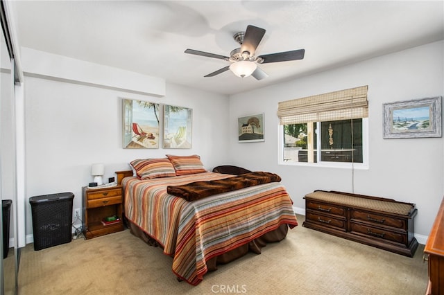 bedroom with a ceiling fan, baseboards, and light colored carpet