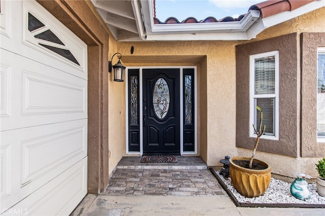 doorway to property featuring stucco siding