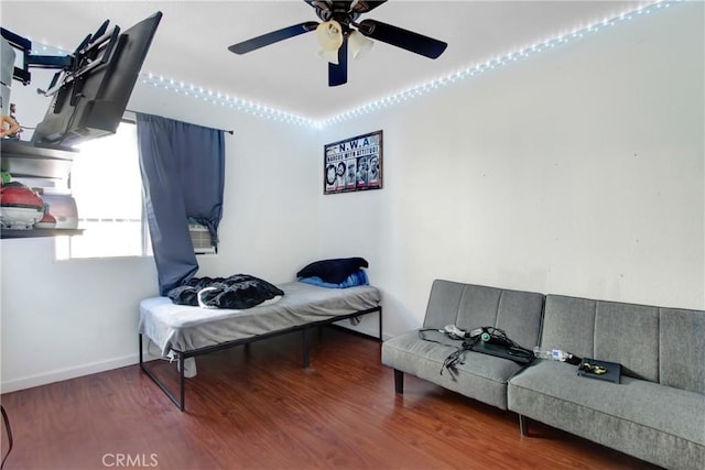 bedroom featuring baseboards, a ceiling fan, and wood finished floors