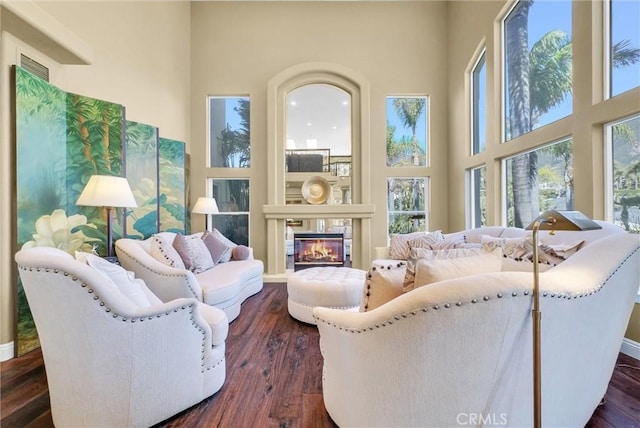 10817 Carriage Dr, Rancho Cucamonga, CA 91737 - living area with a glass covered fireplace, a towering ceiling, and dark wood-style flooring