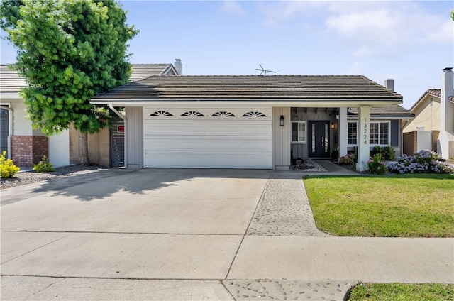 ranch-style home featuring a garage, a front lawn, board and batten siding, driveway, and a tile roof