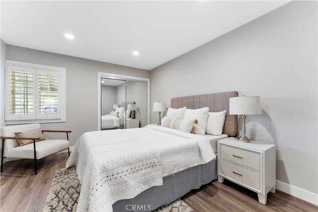 bedroom featuring baseboards, a closet, recessed lighting, and wood finished floors