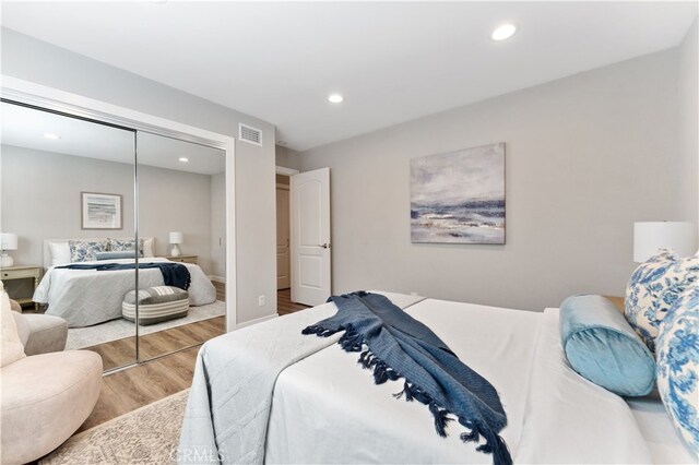 bedroom featuring visible vents, recessed lighting, wood finished floors, and a closet