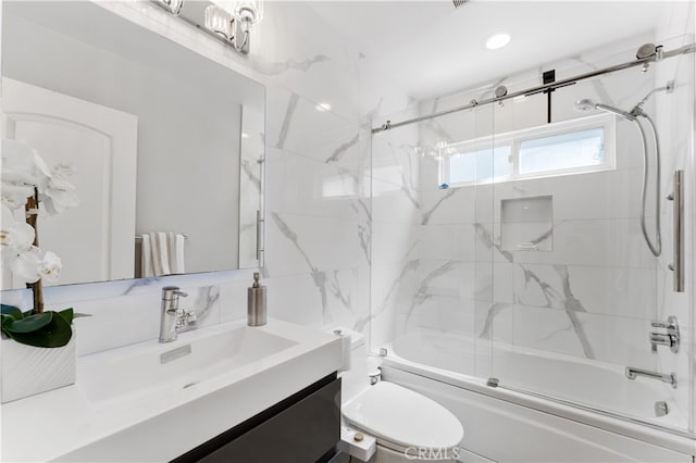 bathroom featuring toilet, enclosed tub / shower combo, and vanity