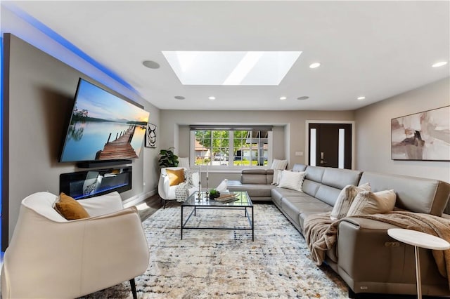 living area featuring a skylight, baseboards, recessed lighting, and wood finished floors