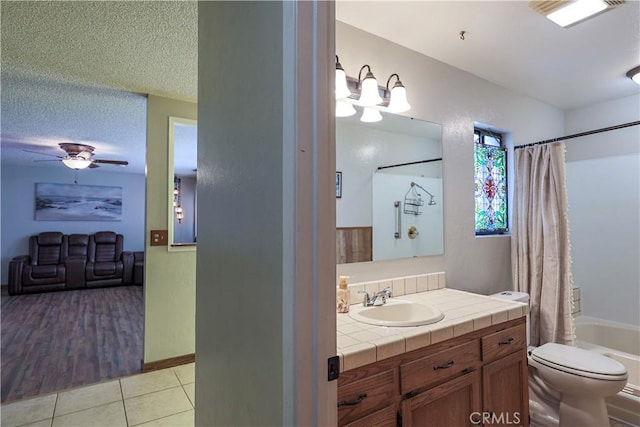 full bath with vanity, tile patterned floors, a ceiling fan, toilet, and shower / bath combo with shower curtain