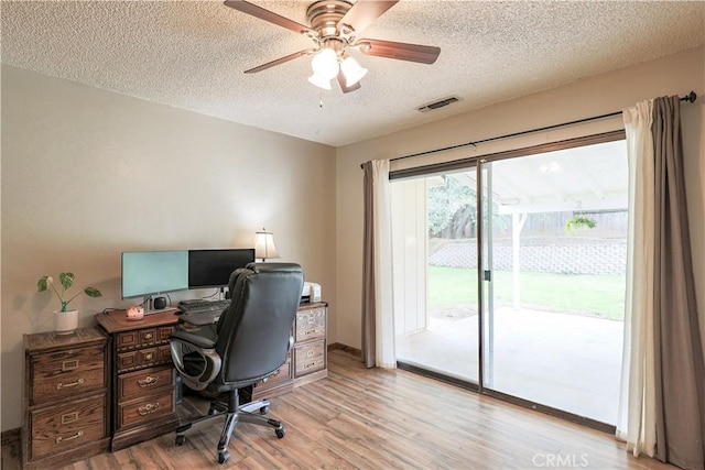 office area featuring visible vents, baseboards, ceiling fan, a textured ceiling, and light wood-style flooring