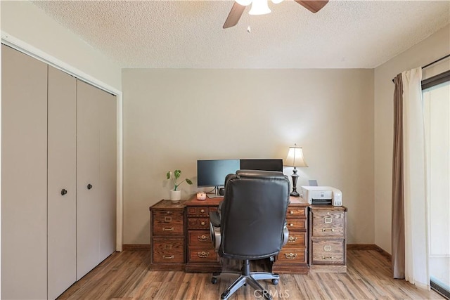 office with a textured ceiling, wood finished floors, baseboards, and a ceiling fan