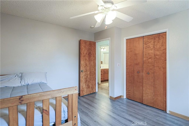 bedroom featuring a textured ceiling, wood finished floors, and baseboards
