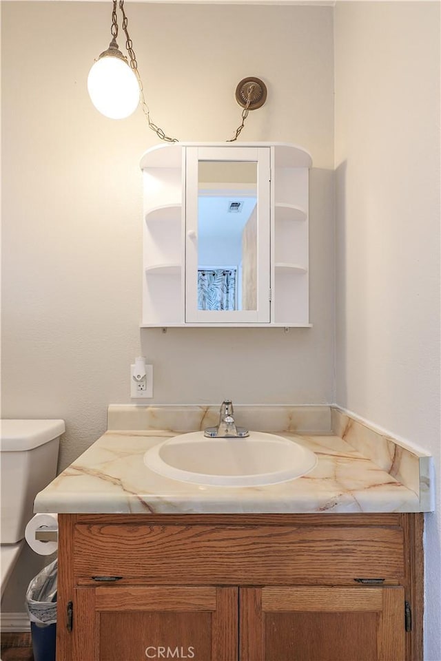 bathroom featuring visible vents, toilet, and vanity