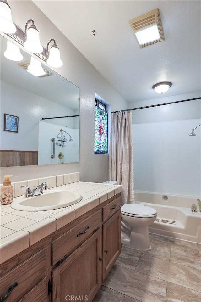 bathroom featuring toilet, visible vents, shower / tub combo with curtain, and vanity
