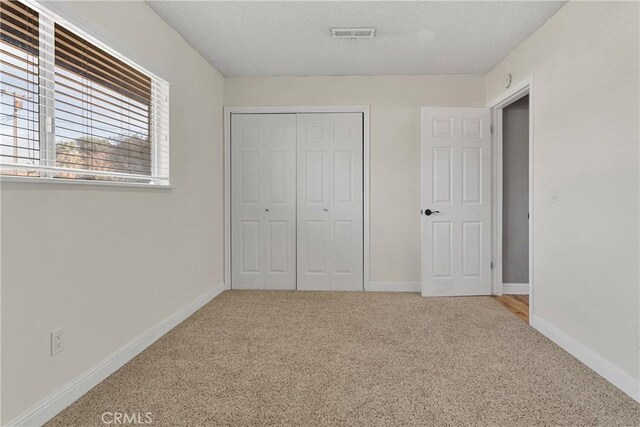 13206 Winona Rd, Apple Valley, CA 92308 - unfurnished bedroom featuring a closet, baseboards, visible vents, a textured ceiling, and carpet floors