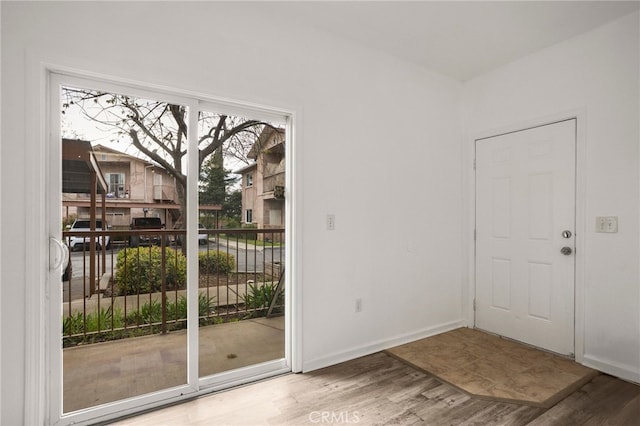 entryway featuring baseboards and wood finished floors