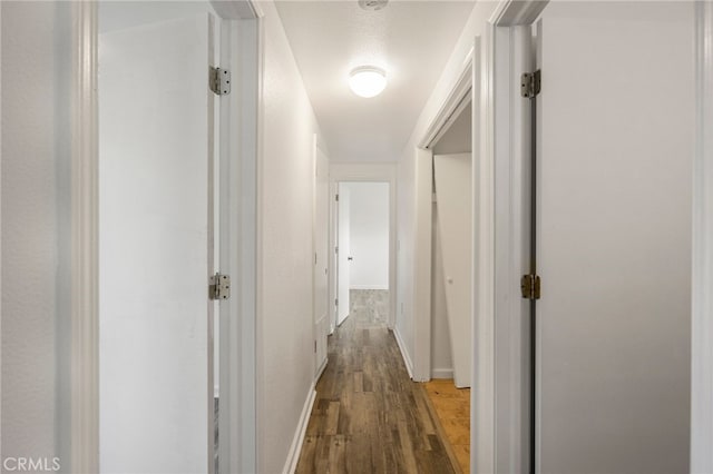 hall featuring baseboards and wood finished floors