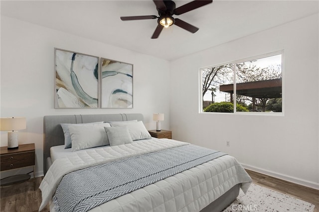 bedroom with baseboards, ceiling fan, and wood finished floors