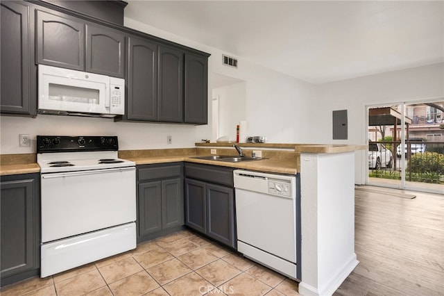 kitchen with white appliances, a peninsula, light countertops, visible vents, and a sink