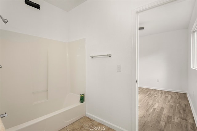 bathroom with baseboards and shower / bathtub combination