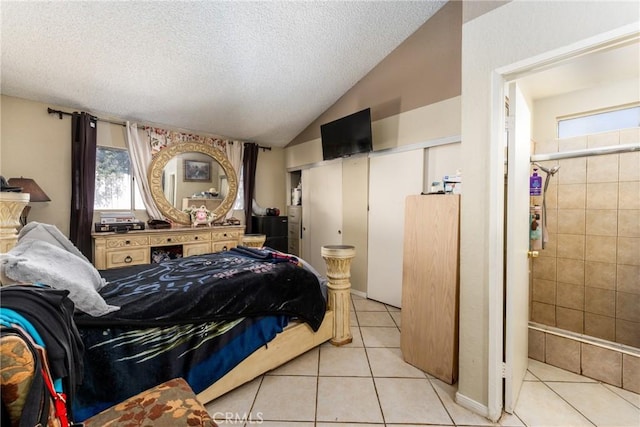 tiled bedroom featuring a textured ceiling and vaulted ceiling