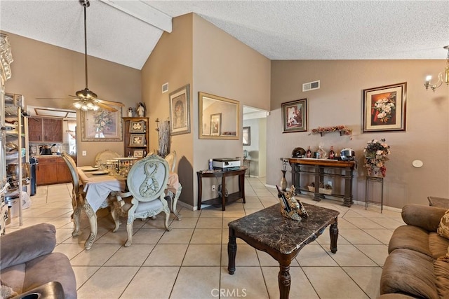 living room with a textured ceiling, light tile patterned floors, high vaulted ceiling, ceiling fan, and baseboards