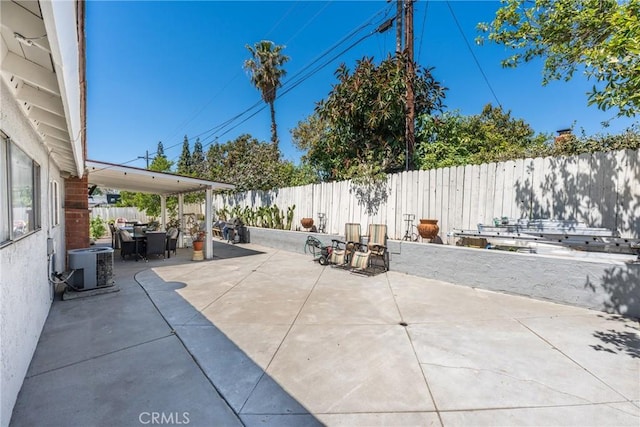 view of patio featuring outdoor dining space, central AC, and a fenced backyard