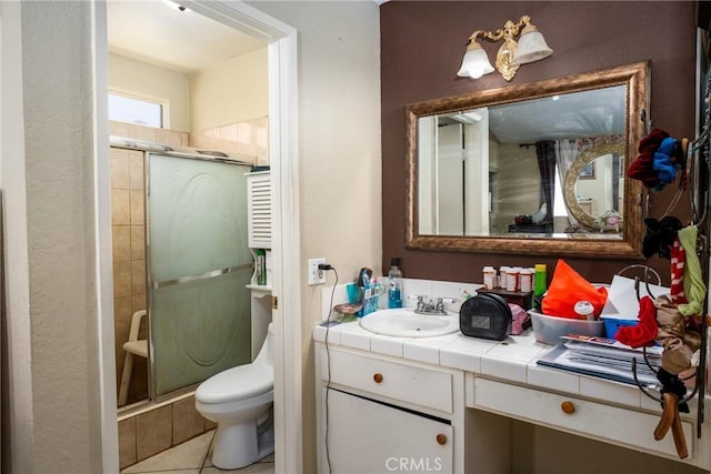 bathroom featuring a stall shower, toilet, vanity, and tile patterned flooring