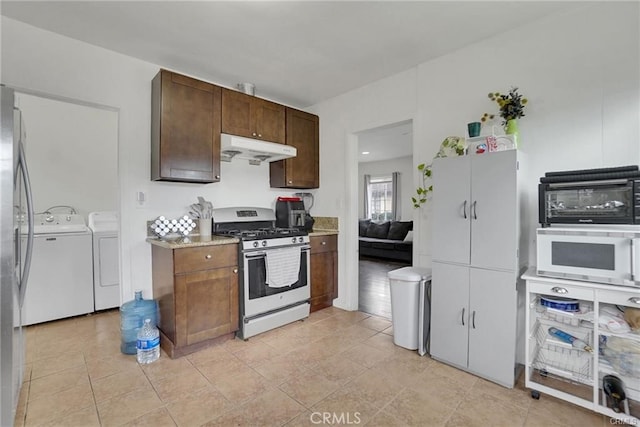 13031305 E Kingsley Ave, Pomona, CA 91767 - kitchen with stainless steel range with gas stovetop, separate washer and dryer, under cabinet range hood, a toaster, and light tile patterned flooring