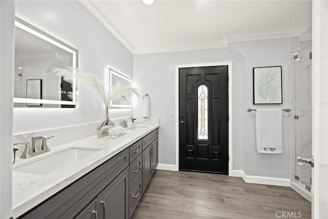 334 Anita Dr, Pasadena, CA 91105 - bathroom featuring ornamental molding, wood finished floors, double vanity, baseboards, and a shower with door